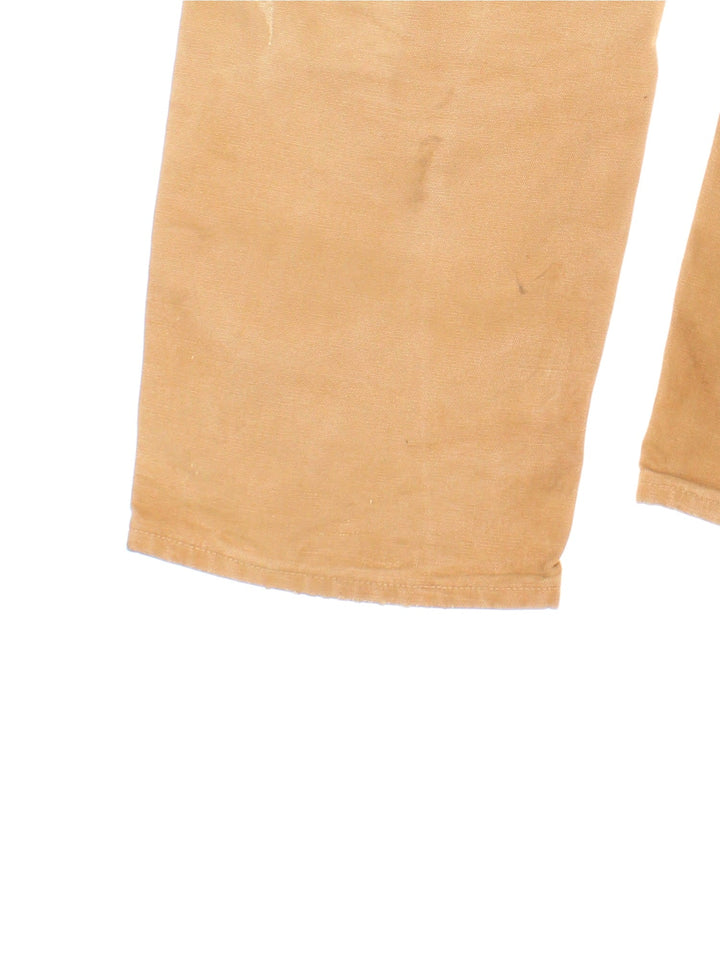 Carhartt Double Knee Jeans in a tan colourway with multiple pockets and the logo embroidered on the back.