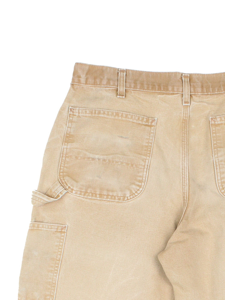 Carhartt Carpenter Jeans in a tan colourway with multiple pockets and the logo embroidered on the back.