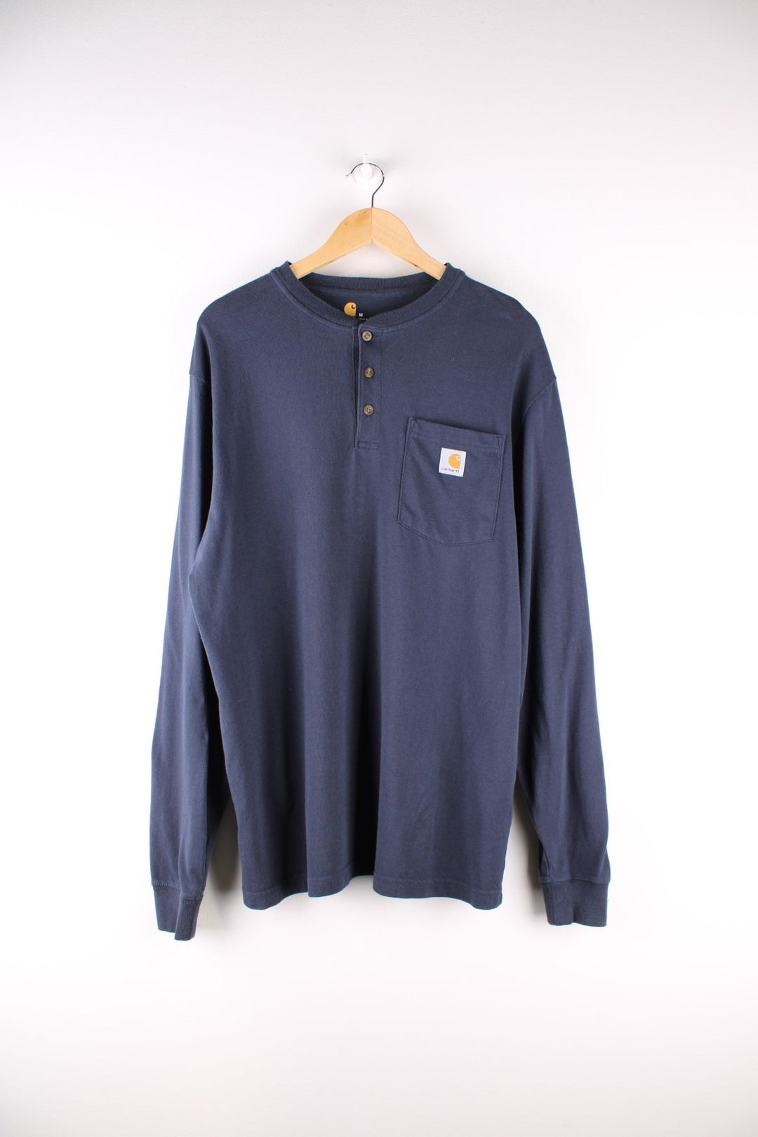 Carhartt longsleeve T-Shirt in a navy blue colourway with a patch pocket and logo stitched onto the front. 3 button neck closure. 