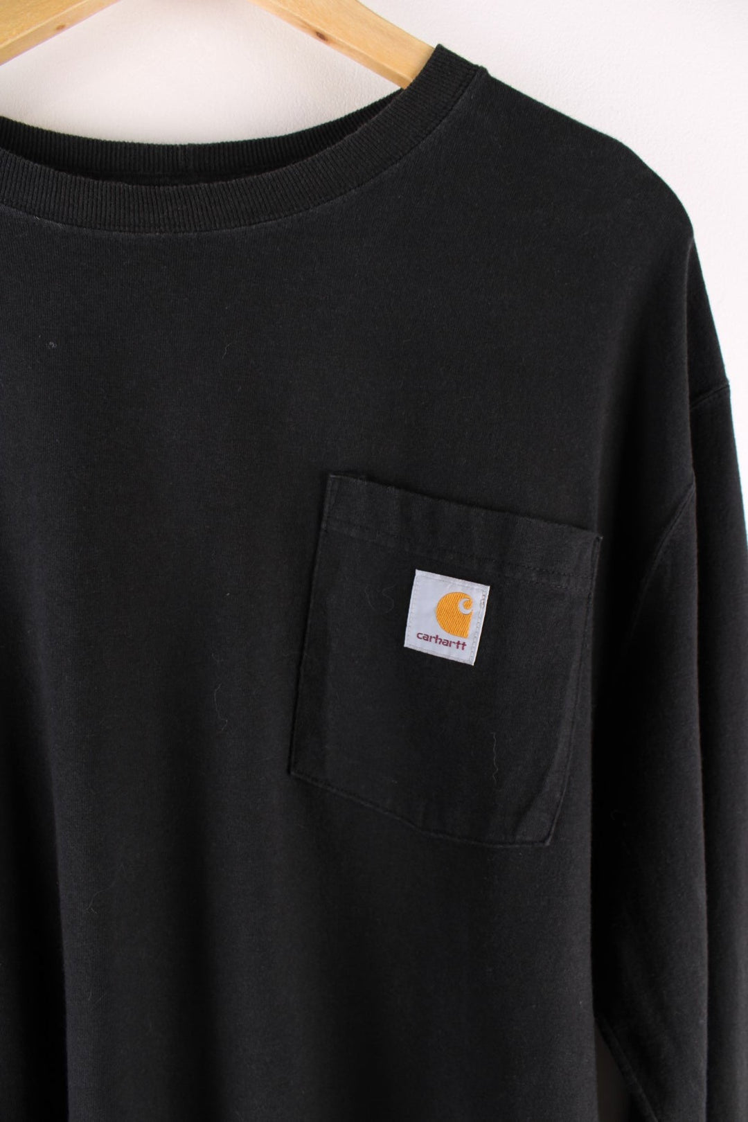 Carhartt longsleeve T-Shirt in a black colourway with a patch pocket, and logo embroidered on the front.