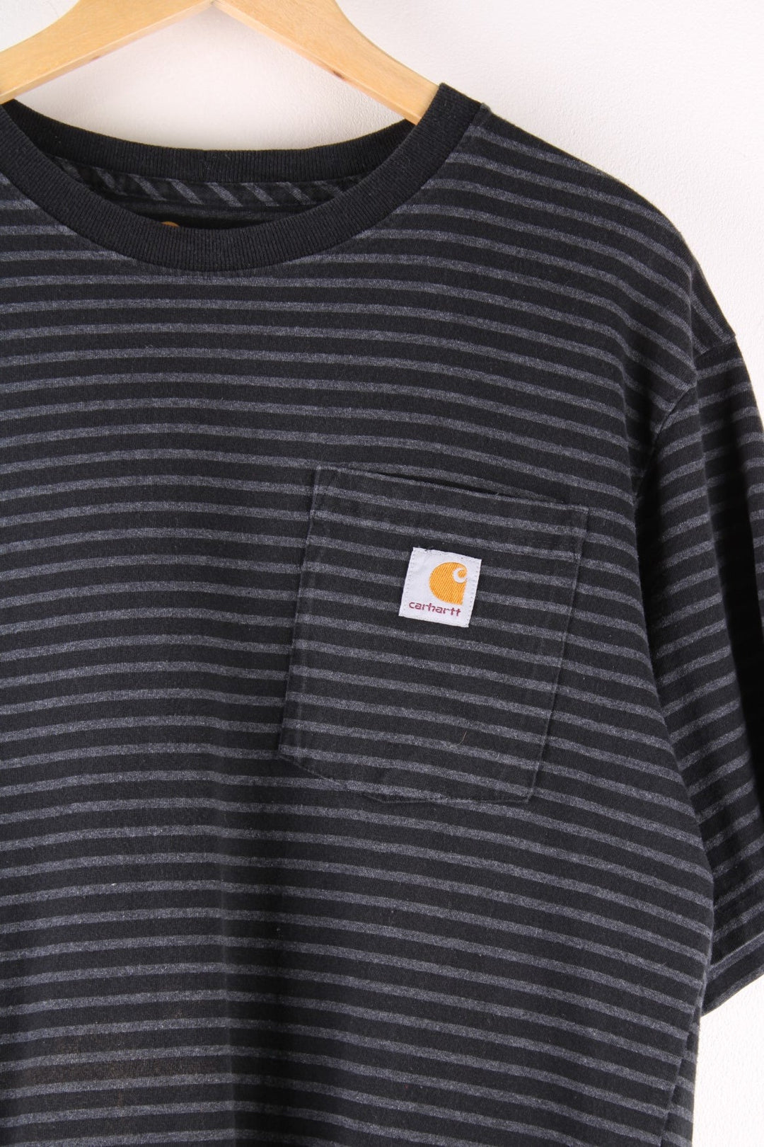 Carhartt T-Shirt in a grey and black striped colourway, with a patch pocket and logo embroidered on the front. 