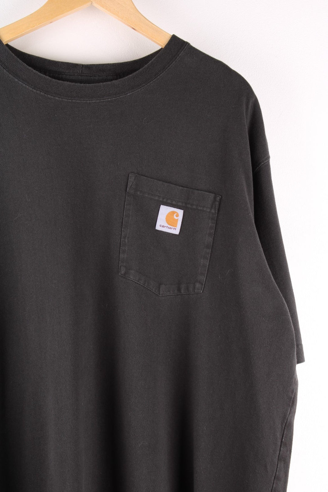 Carhartt T-Shirt in a black colourway with a patch pocket and logo stitched onto the front. 