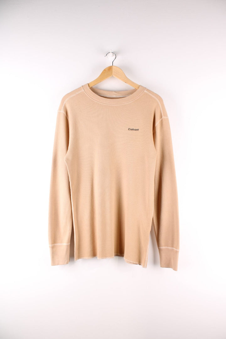 Carhartt longsleeve thermal style undershirt in a tan colourway with a small Carhartt logo printed on the front and overlocked seam details. 