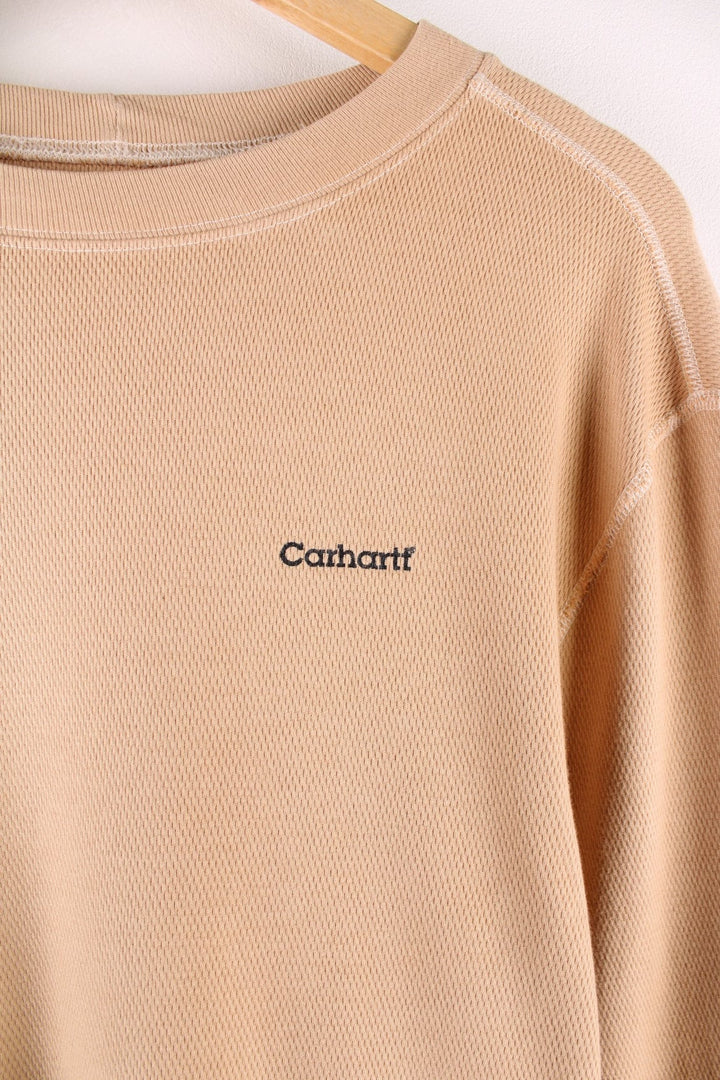 Carhartt longsleeve thermal style undershirt in a tan colourway with a small Carhartt logo printed on the front and overlocked seam details. 