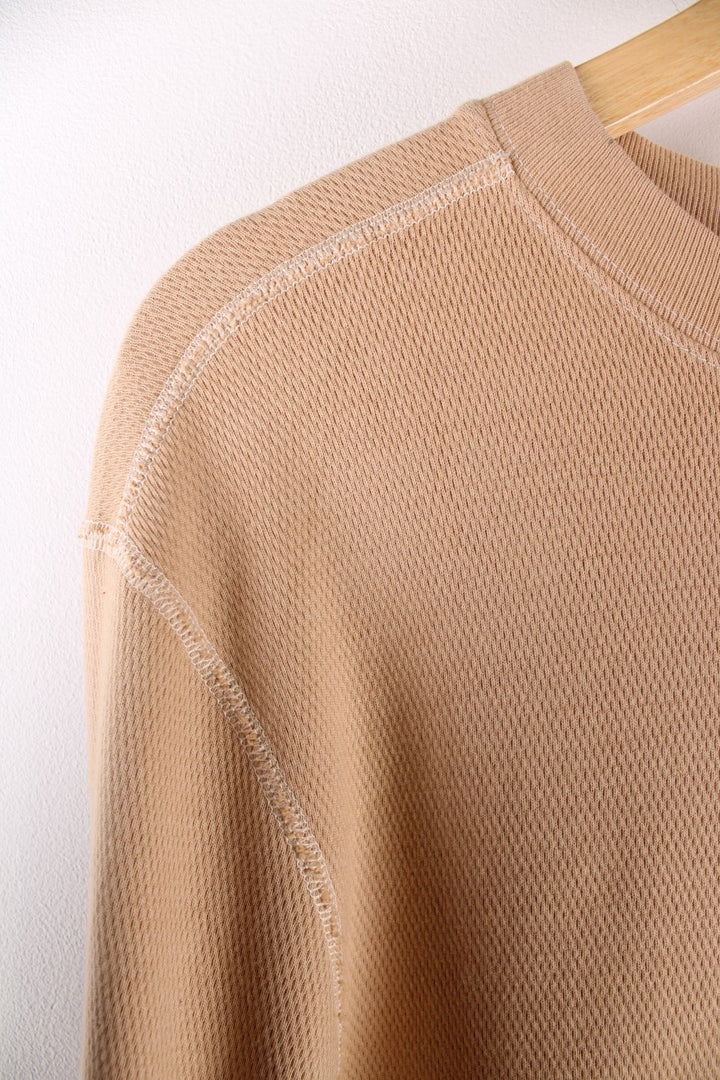 Carhartt longsleeve thermal style undershirt in a tan colourway with a small Carhartt logo printed on the front and overlocked seam details. 