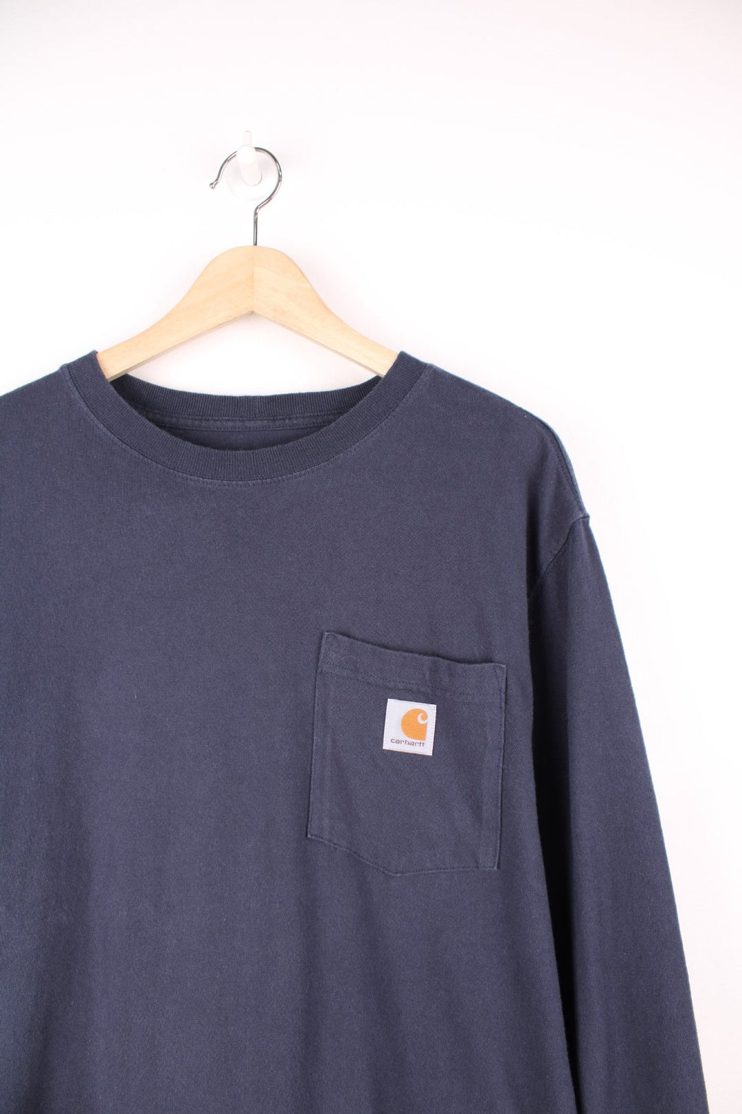 Navy blue Carhartt Loose Fit long sleeved T-Shirt with chest pocket and embroidered logo.