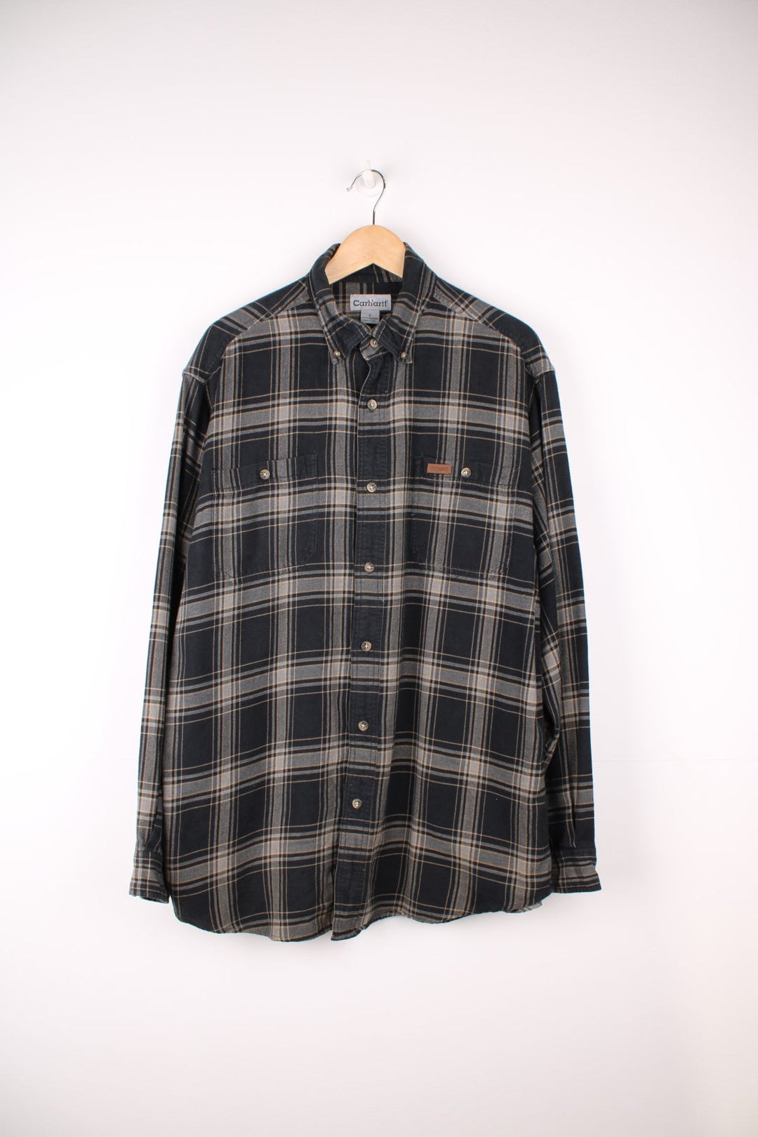 Carhartt black and grey tone button up flannel shirt. Made from 100% cotton, features double chest pockets and leather embossed logo on the pocket