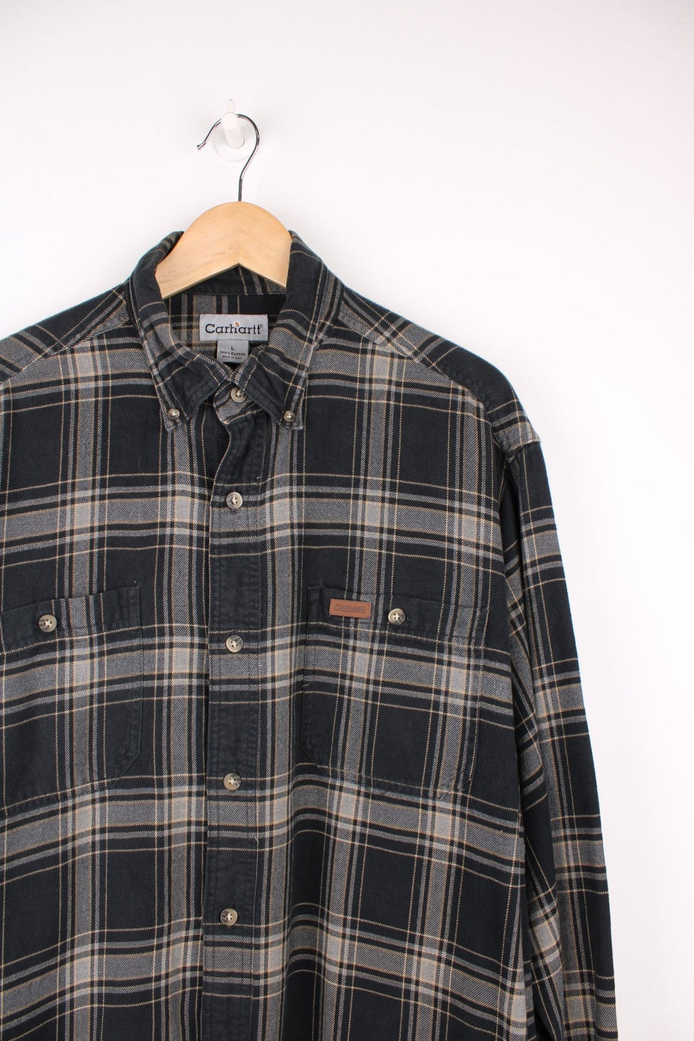 Carhartt black and grey tone button up flannel shirt. Made from 100% cotton, features double chest pockets and leather embossed logo on the pocket