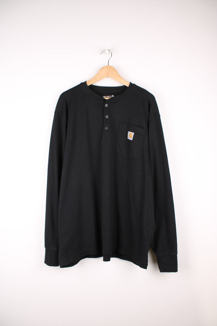 Carhartt 'loose fit' heavy weight black long sleeve top. Features signature logo on the chest pocket and three button fastening 