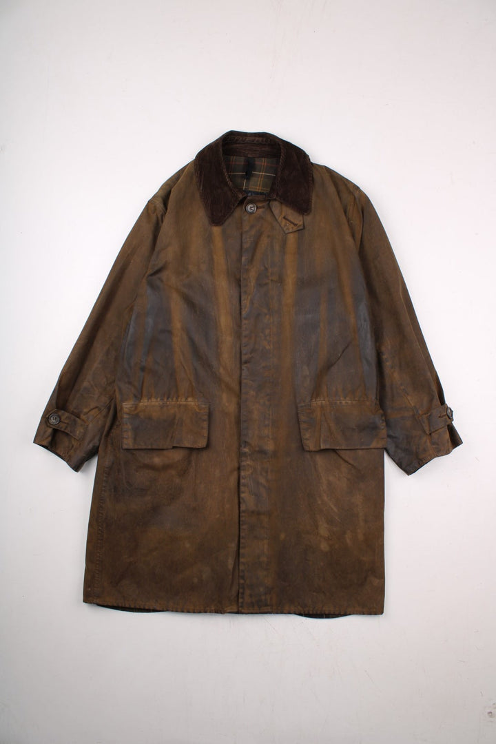 Barbour 3/4 length waxed jacket in brown with multiple pockets, button closure, and a corduroy collar.