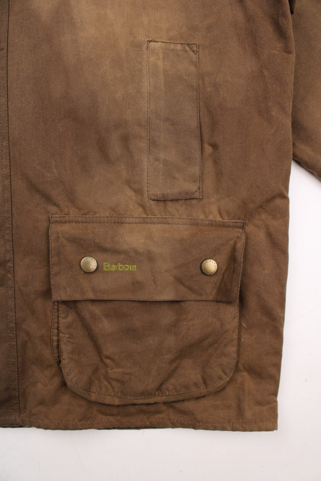 Barbour waxed jacket in brown with multiple pockets, zip closure, and a leather collar.