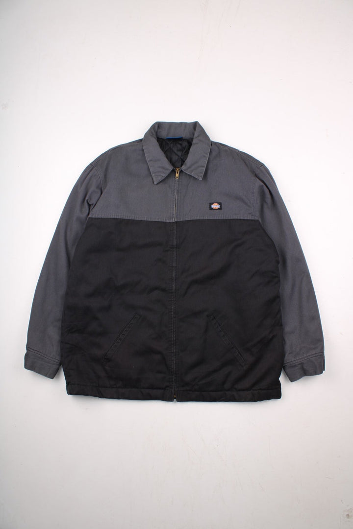 Dickies quilt-lined two-tone Eisenhower jacket in black and grey with two pockets, zip closure, and a small logo patch on the chest.