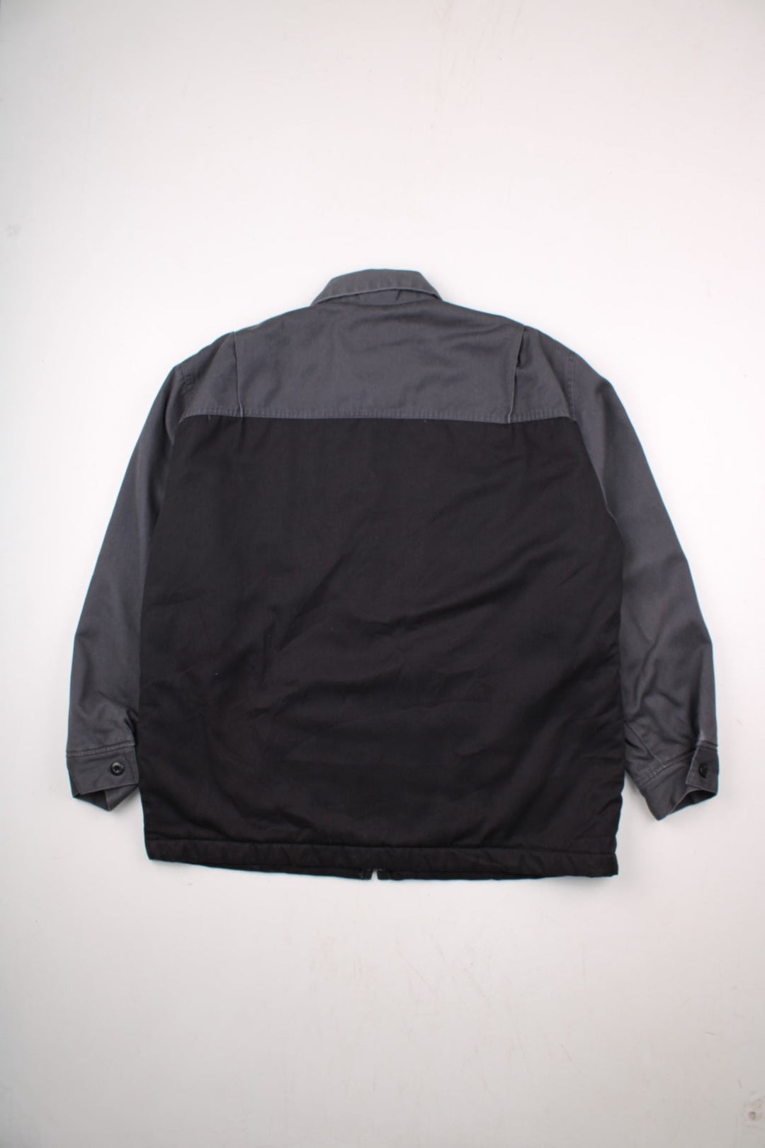 Dickies quilt-lined two-tone Eisenhower jacket in black and grey with two pockets, zip closure, and a small logo patch on the chest.