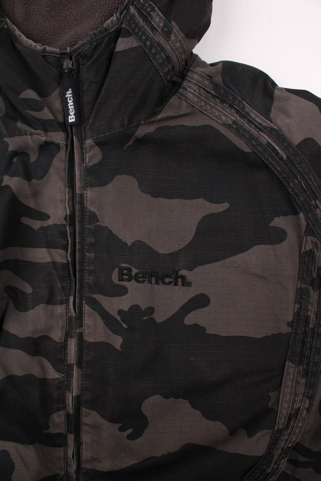 Bench fleece-lined camouflage coat in grey and black with zip closure, two pockets and a hood.