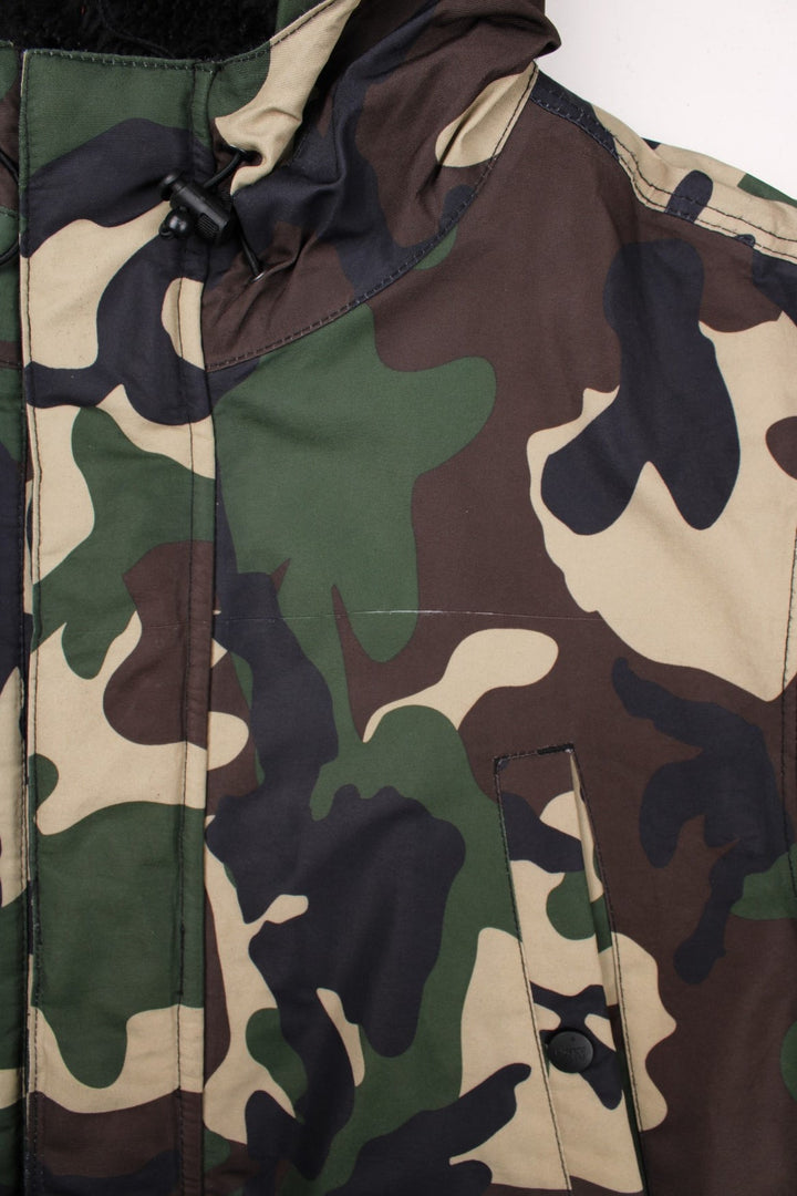 Dickies camouflage parka in green and brown - quilt-lined, with zip and snap closure, multiple pockets, and a sherpa-lined hood. Hood would have originally had detachable fur trim but this is missing.