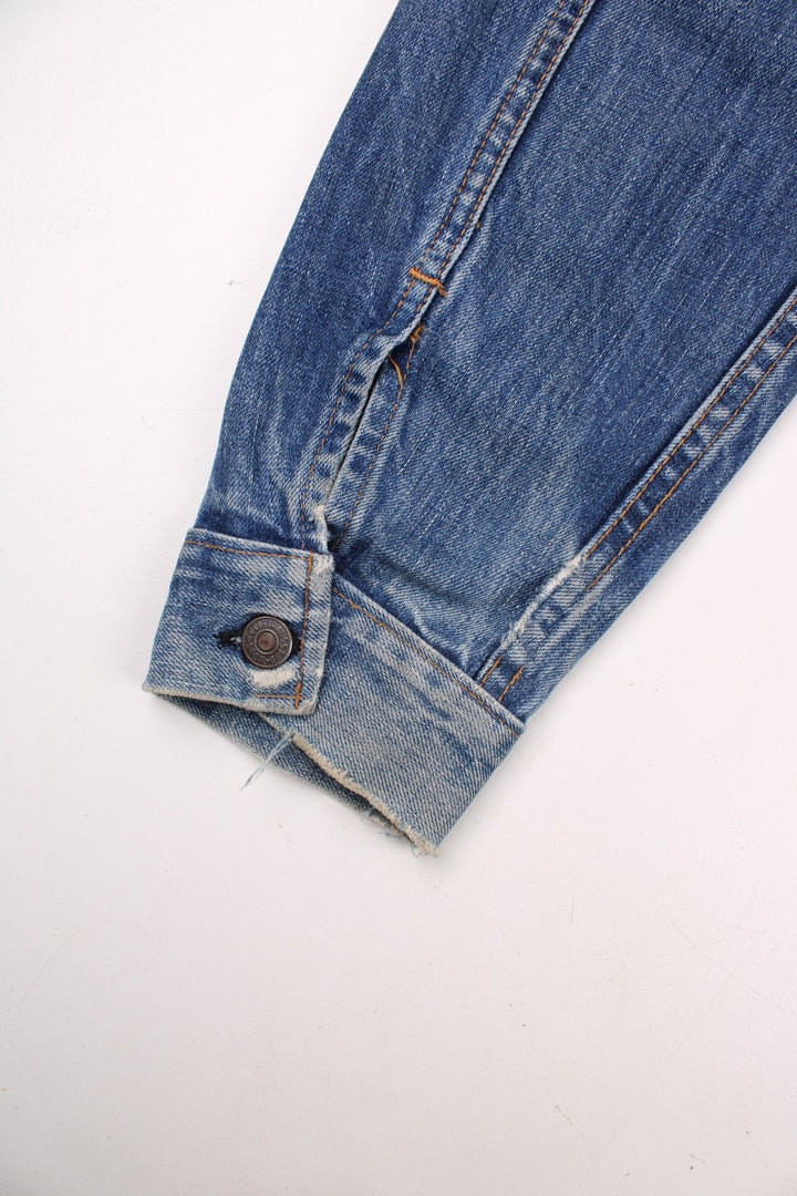 70s Levi Strauss Big E tab denim trucker jacket in blue with two chest pockets and button closure.