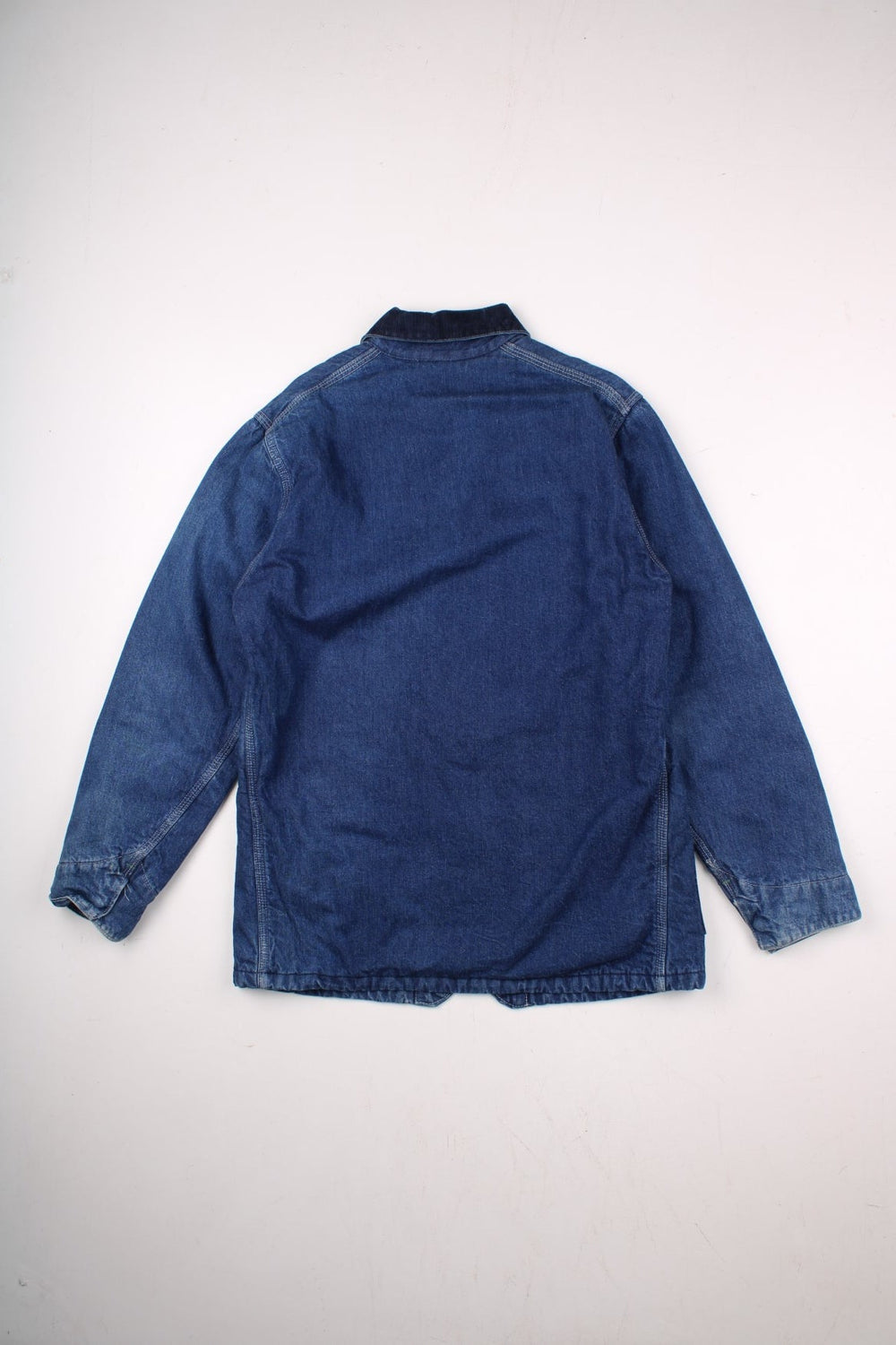 Vintage OshKosh B'Gosh sanforized denim chore jacket in blue with a red quilted lining, four patch pockets, button closure, a corduroy collar, and a small 'OshKosh B'Gosh' logo patch on the front.