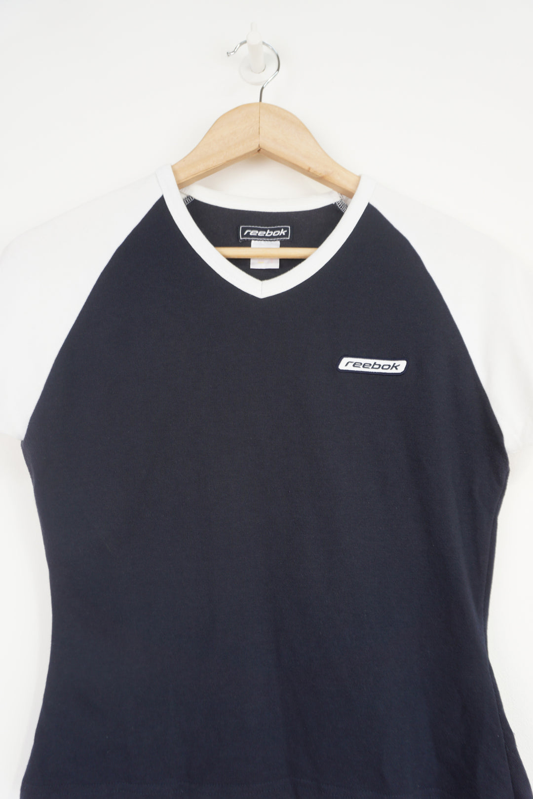 navy blue and white Reebok baby tee style t-shirt with embroidered logo on the chest