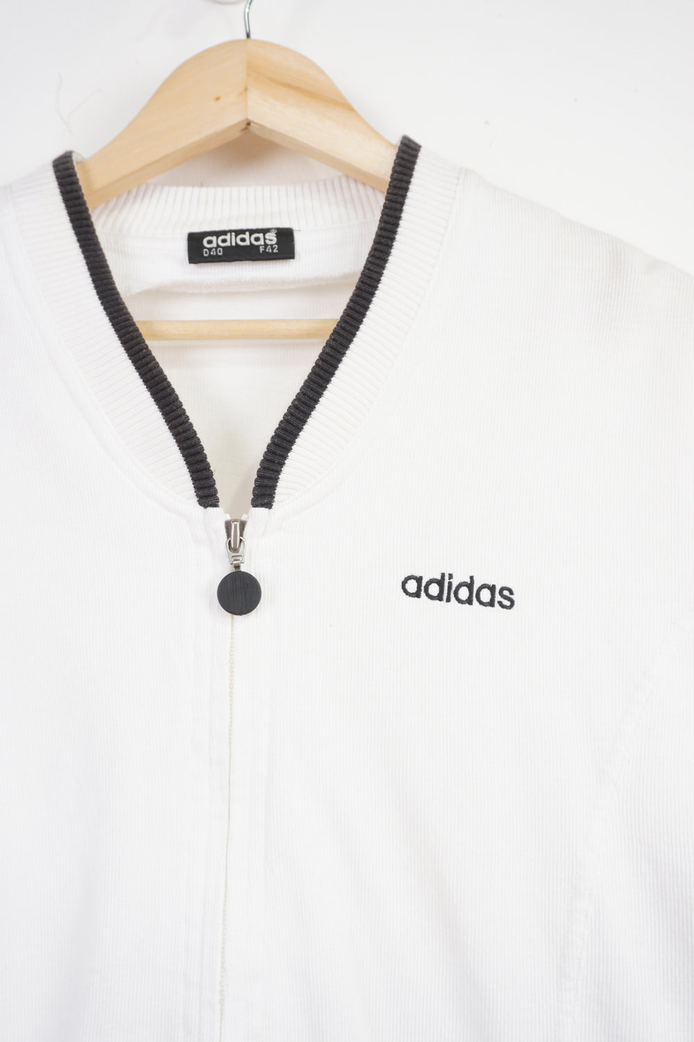 White Adidas zip through crop top with embroidered logo on the front and three stripe details down the side