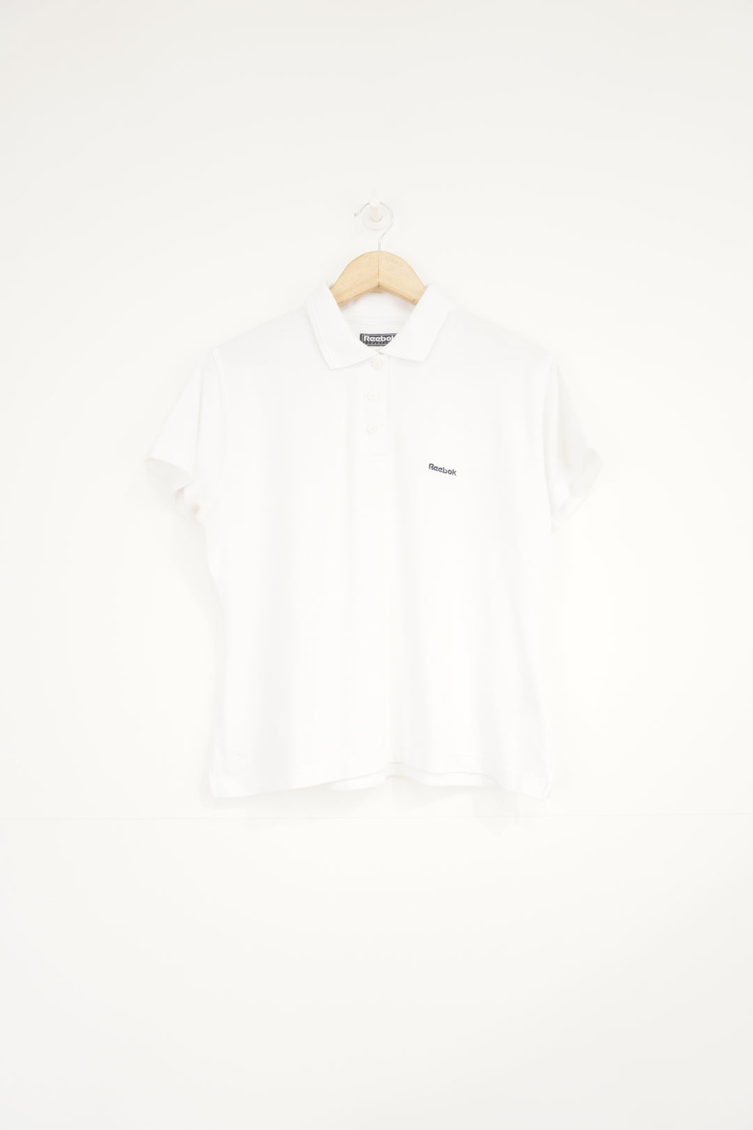 All white Reebok polo shirt with embroidered logo on the chest