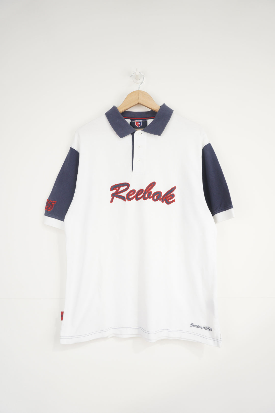 Reebok white and navy polo shirt with embroidered logo across the chest