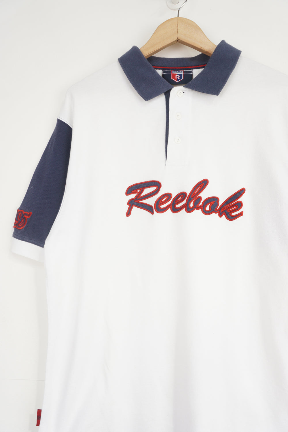 Reebok white and navy polo shirt with embroidered logo across the chest