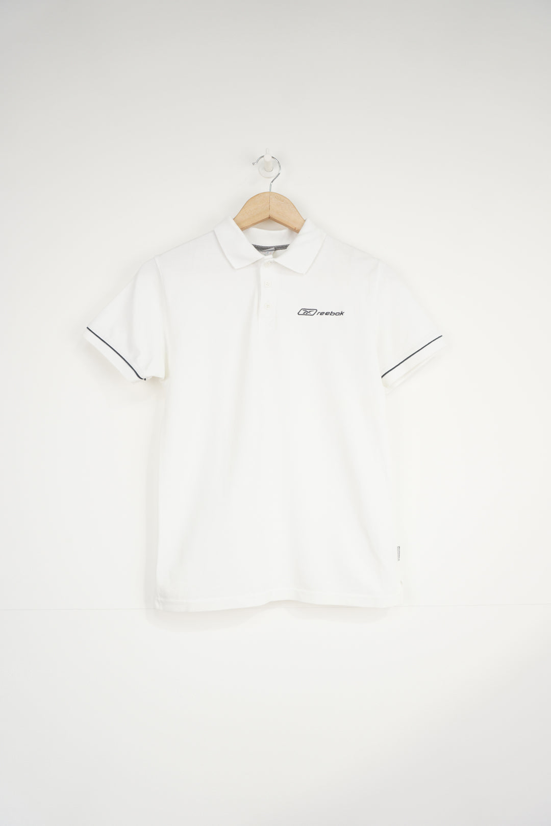 All white Reebok polo shirt with embroidered logo on the chest