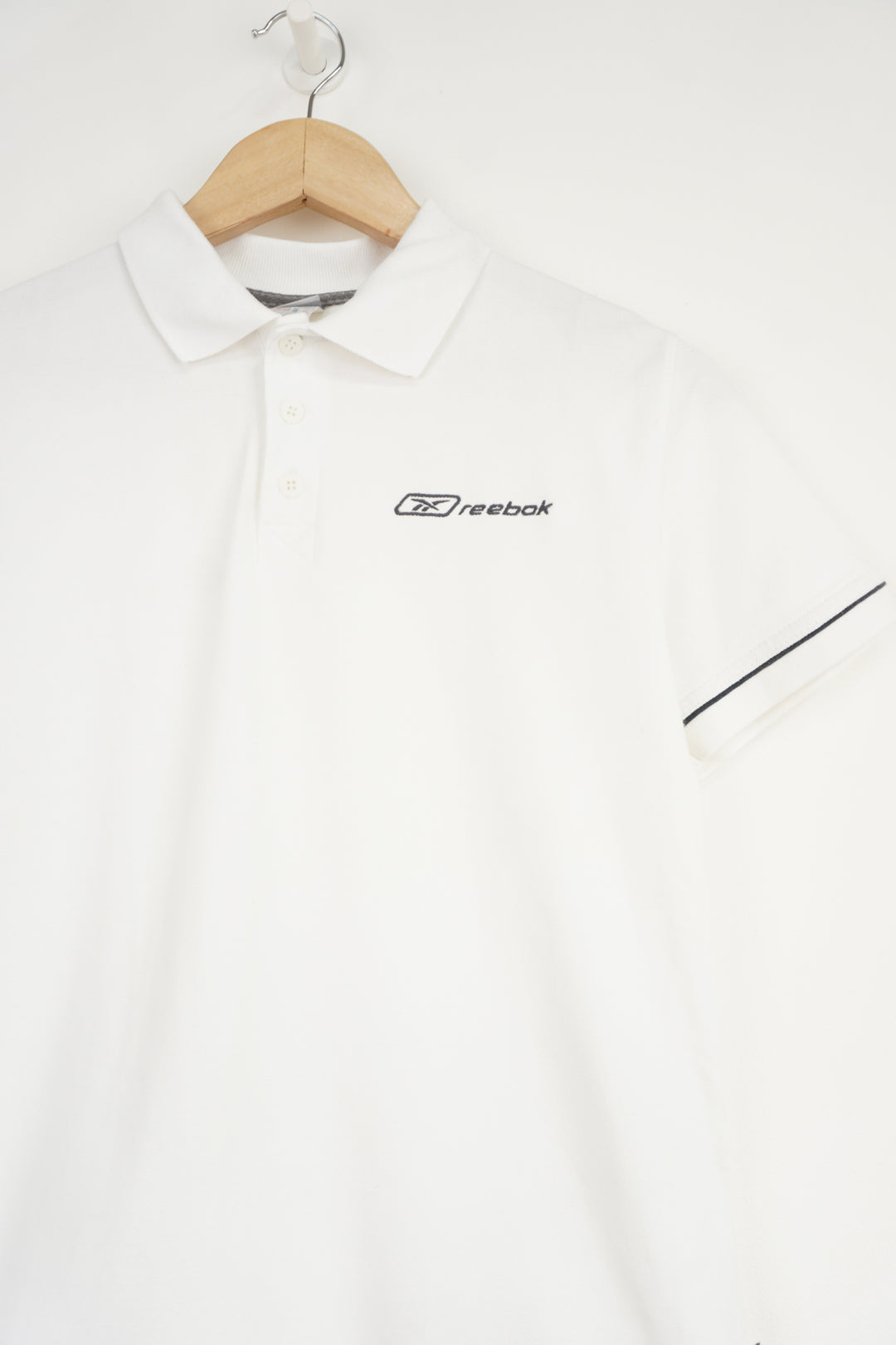 All white Reebok polo shirt with embroidered logo on the chest