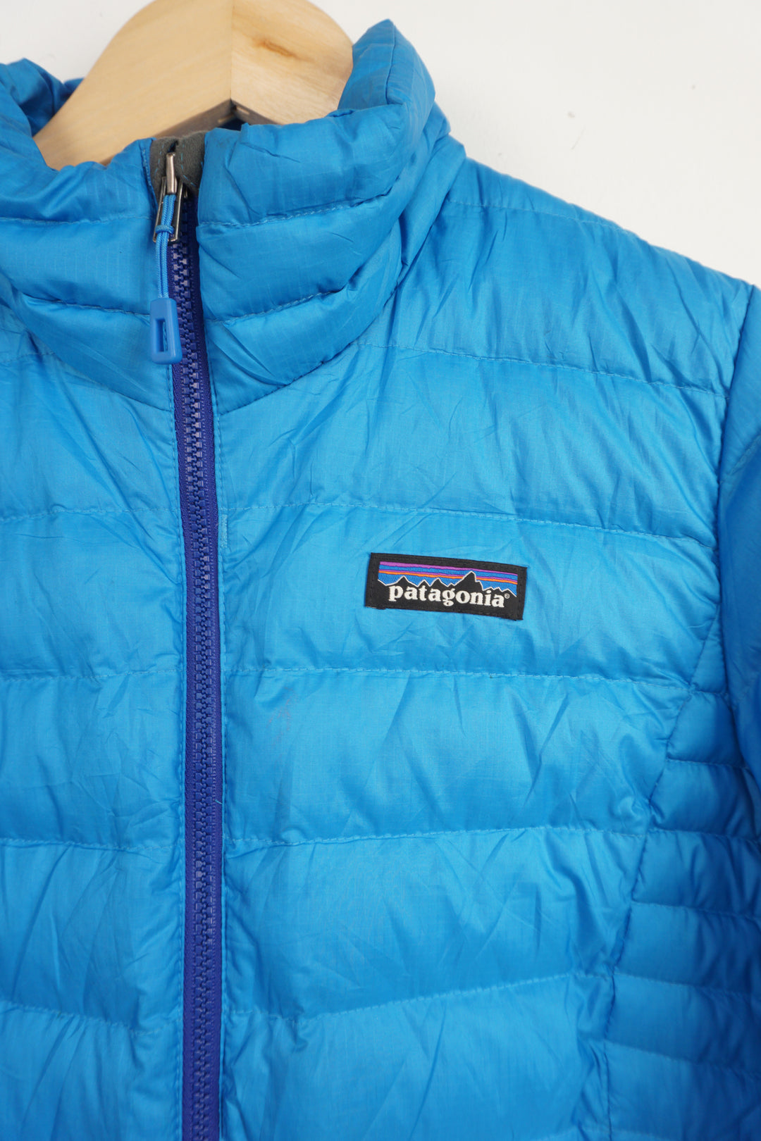 All blue Patagonia lightly padded puffer jacket with zip up pockets and embroidered logo on the chest