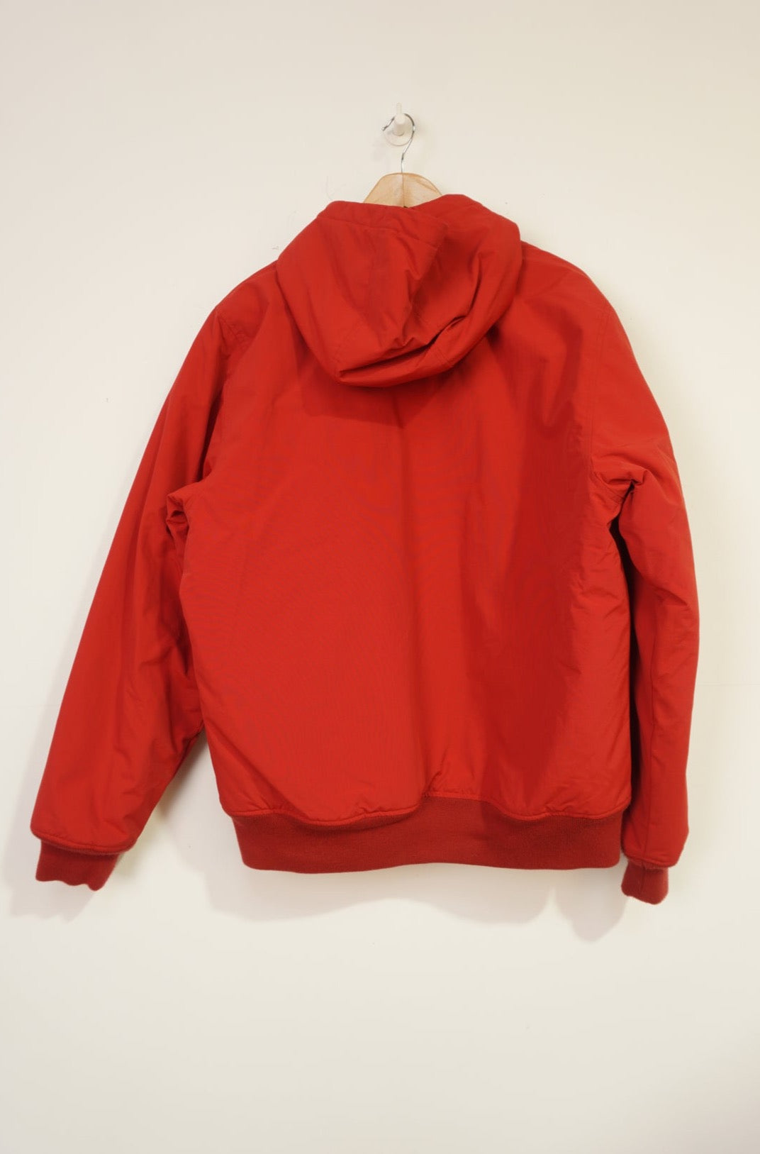 Red Carhartt outdoor coat with zip up pockets and embroidered logo on the chest