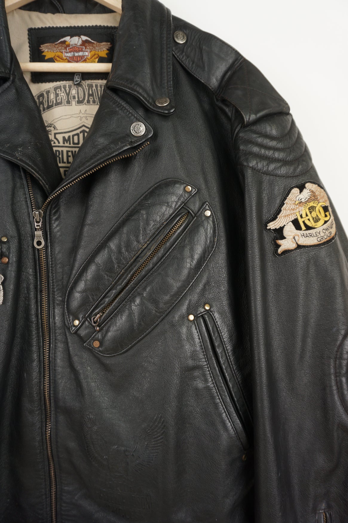 Vintage Harley Davidson black leather motorcycle jacket with embossed eagle design, embroidered badges and multiple pockets