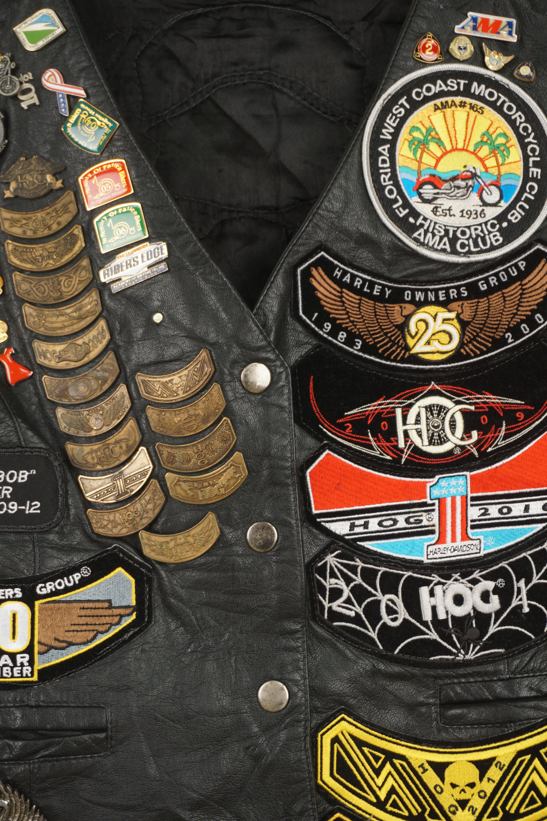 Women's vintage Harley Davidson Owners Group black leather vest with lots of commemorative patches and pins