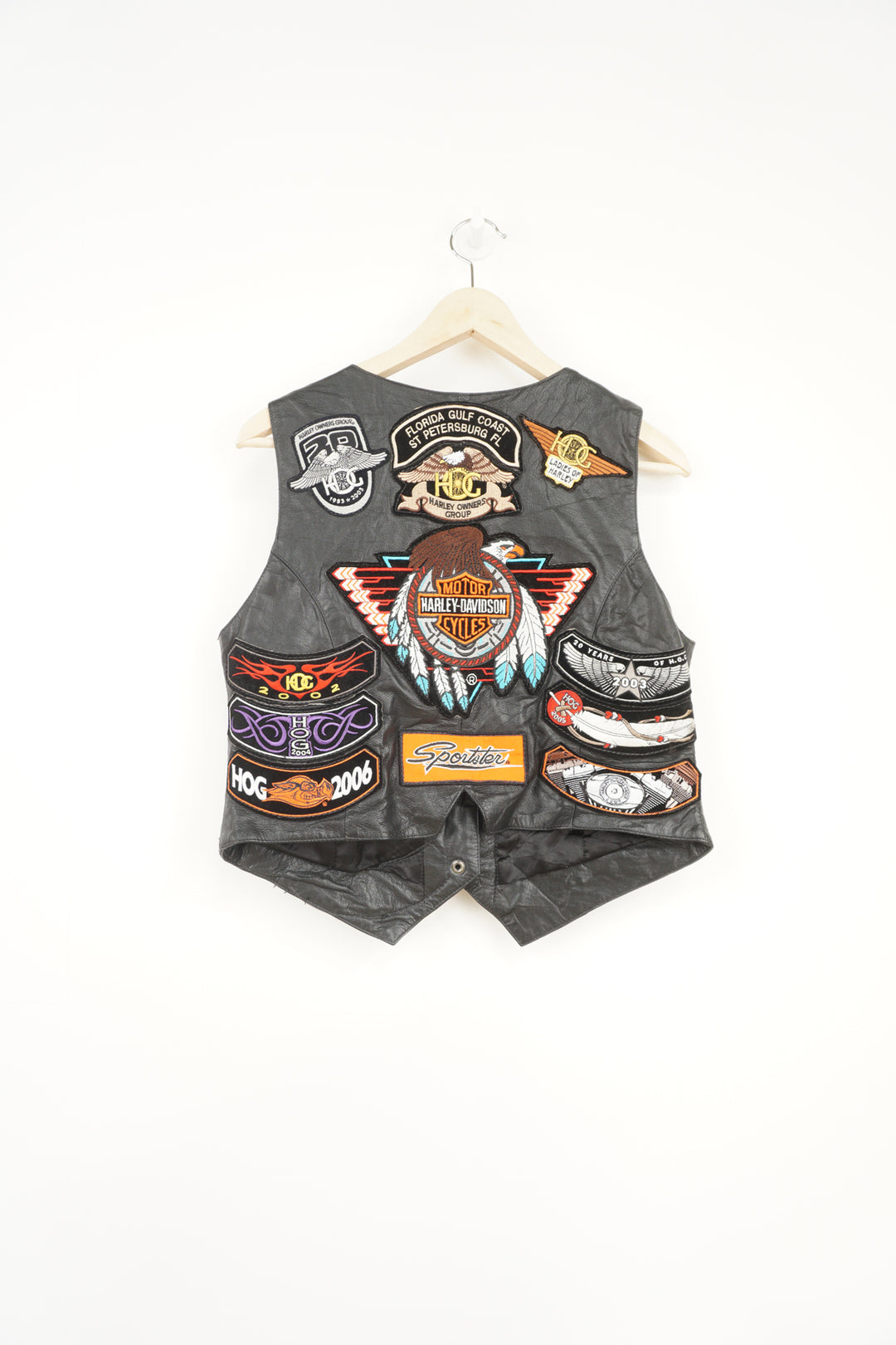 Women's vintage Harley Davidson Owners Group black leather vest with lots of commemorative patches and pins