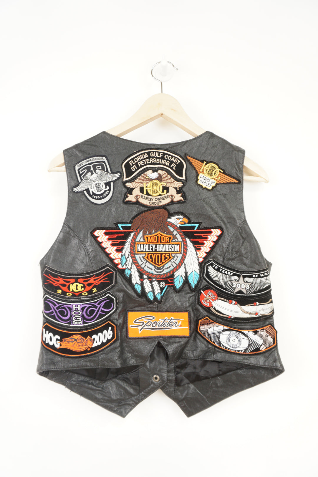 Women's vintage Harley Davidson Owners Group black leather vest with lots of commemorative patches and pins