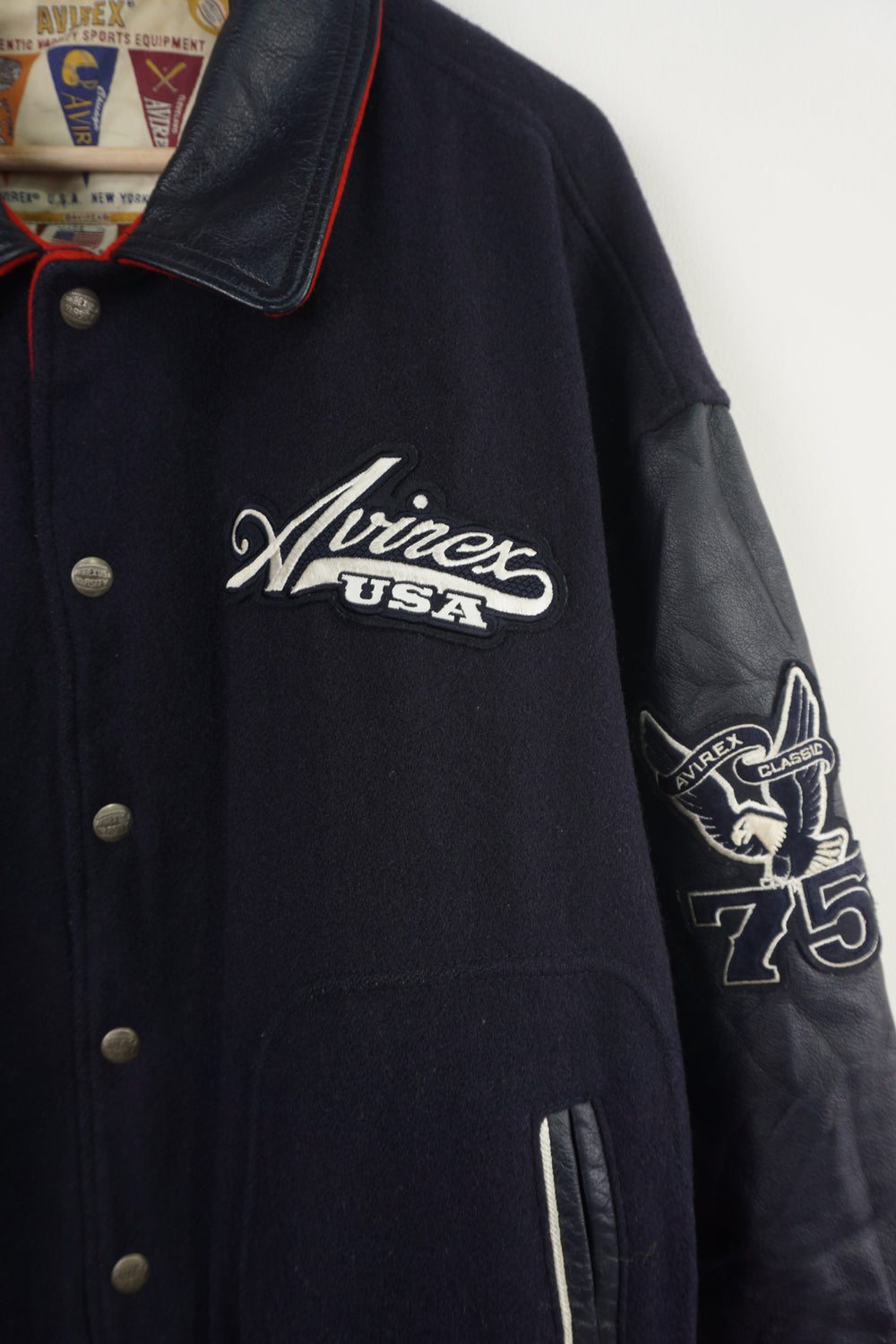 Vintage Avirex USA navy blue Varsity Jacket, embroidered badges on front, sleeve, and back. 