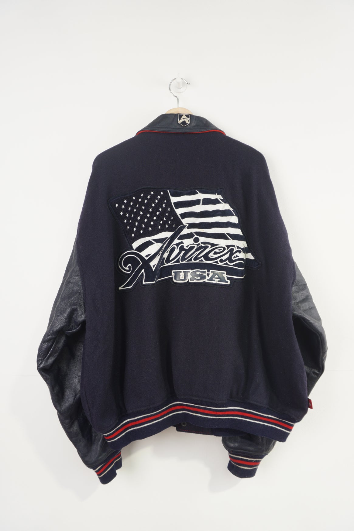 Vintage Avirex USA navy blue Varsity Jacket, embroidered badges on front, sleeve, and back. 