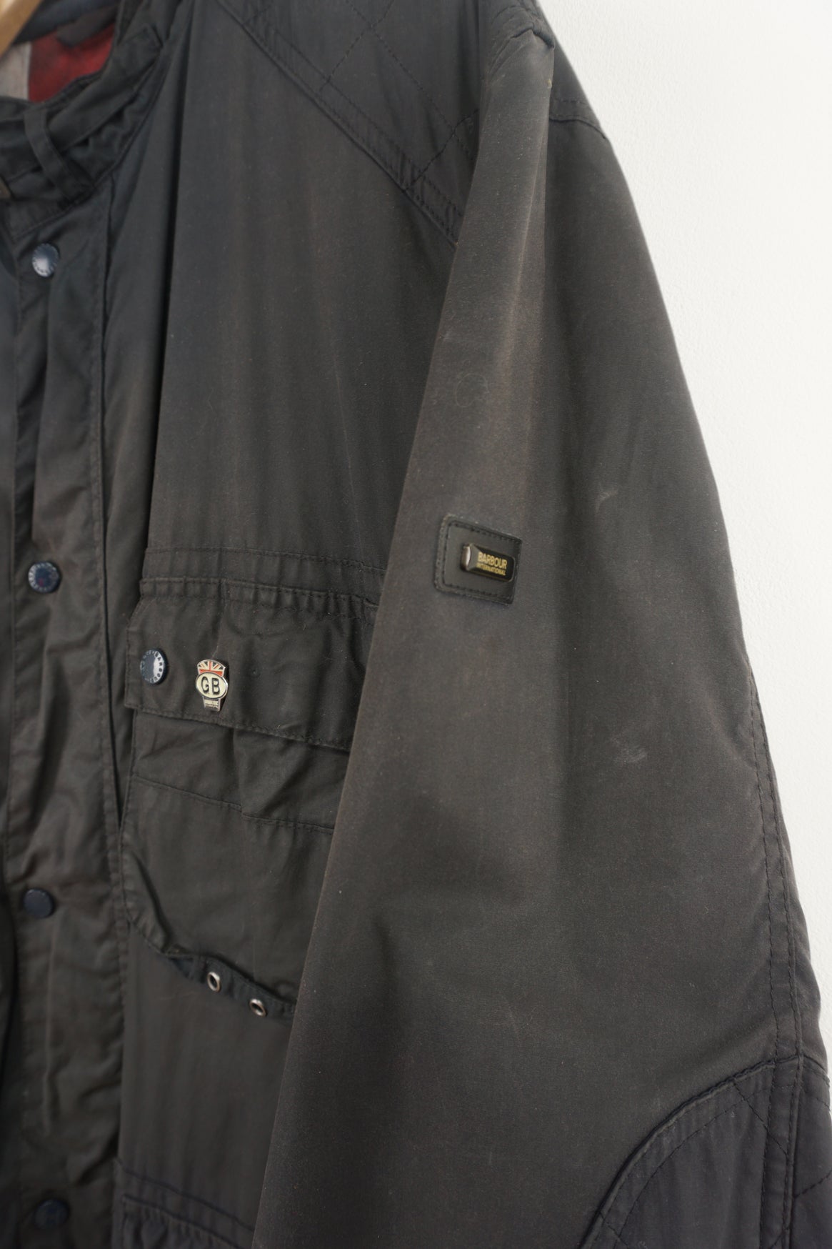 Barbour International wax jacket with multiple pockets and signature logo on the sleeve