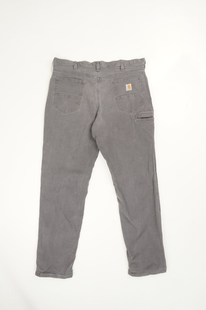 Stone grey Carhartt relaxed fit straight leg jeans with signature logo on the back pocket