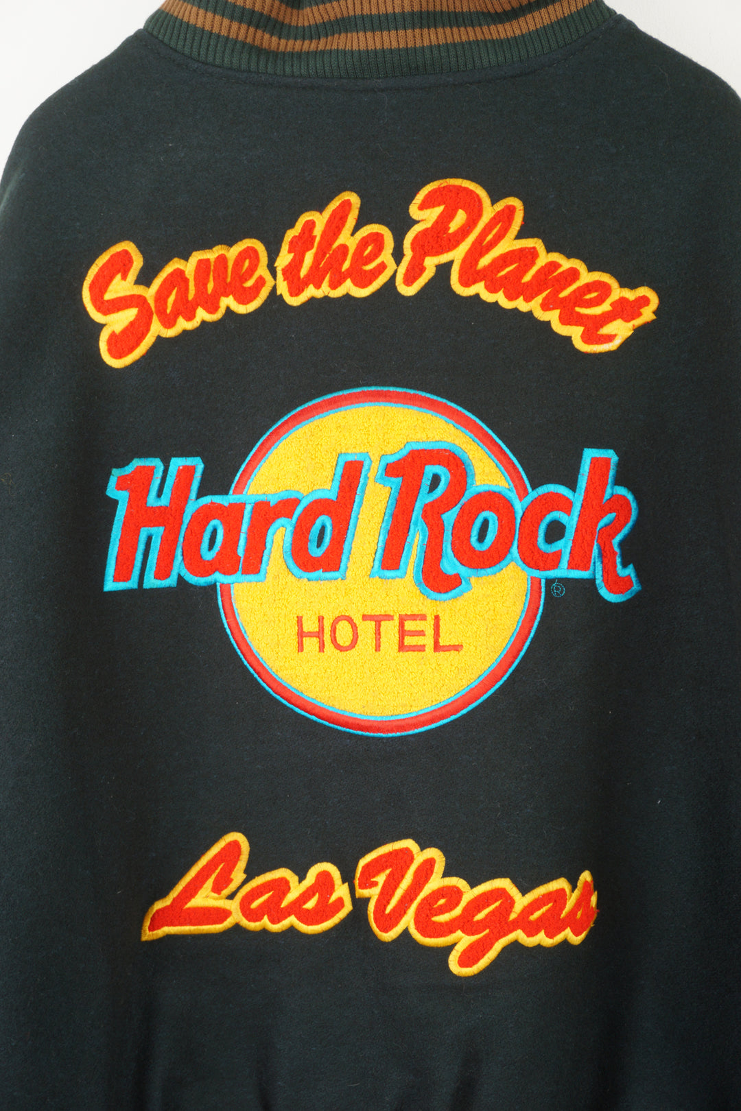 Vintage green wool Hard Rock Hotel Las Vegas varsity jacket with brown leather sleeves.