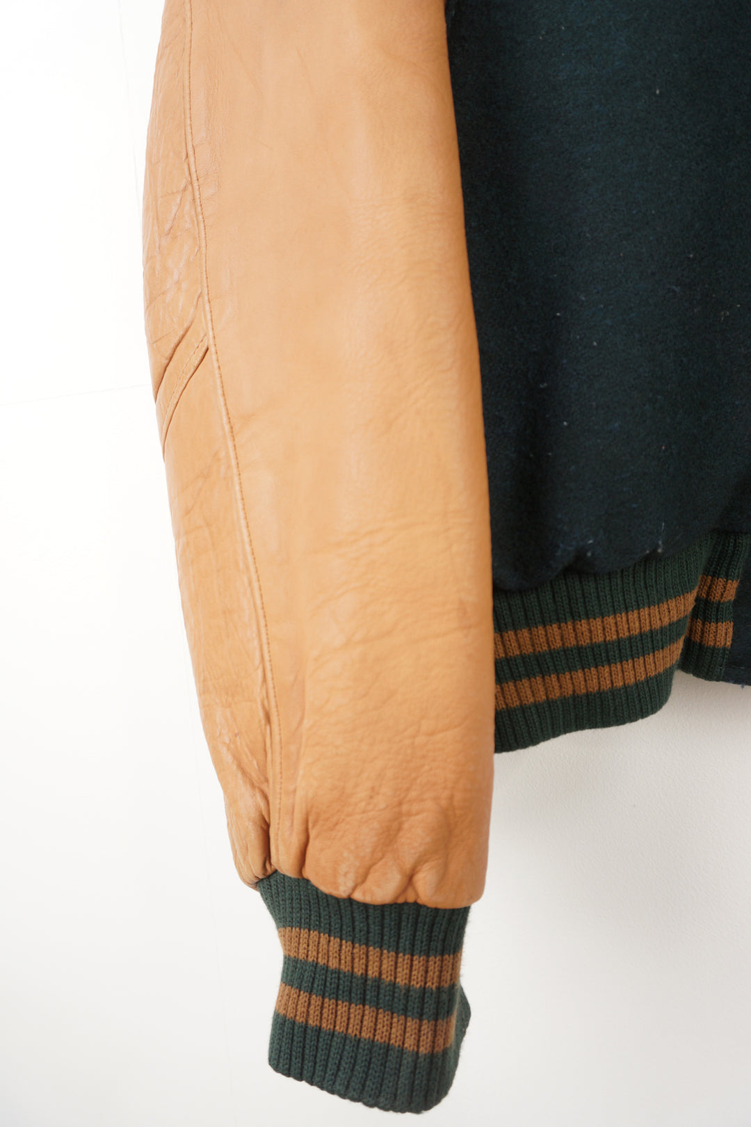 Vintage green wool Hard Rock Hotel Las Vegas varsity jacket with brown leather sleeves.