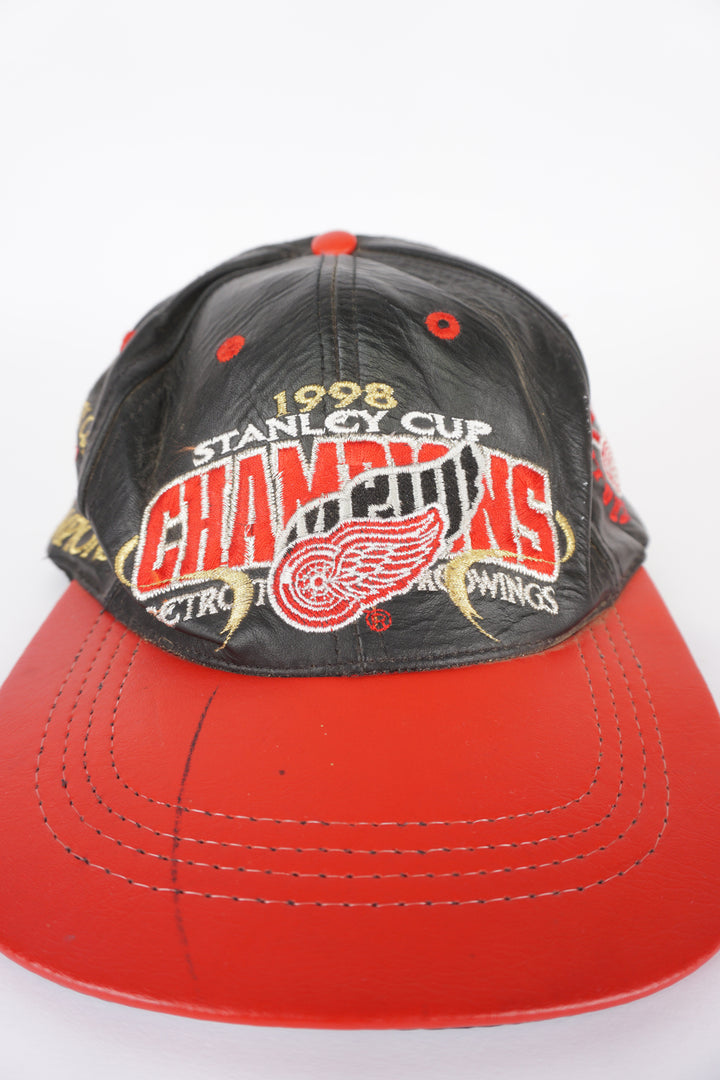 Vintage 1998 Stanley Cup NHL champions: Detroit Red Wings black leather baseball features embroidered badges on the front and sides