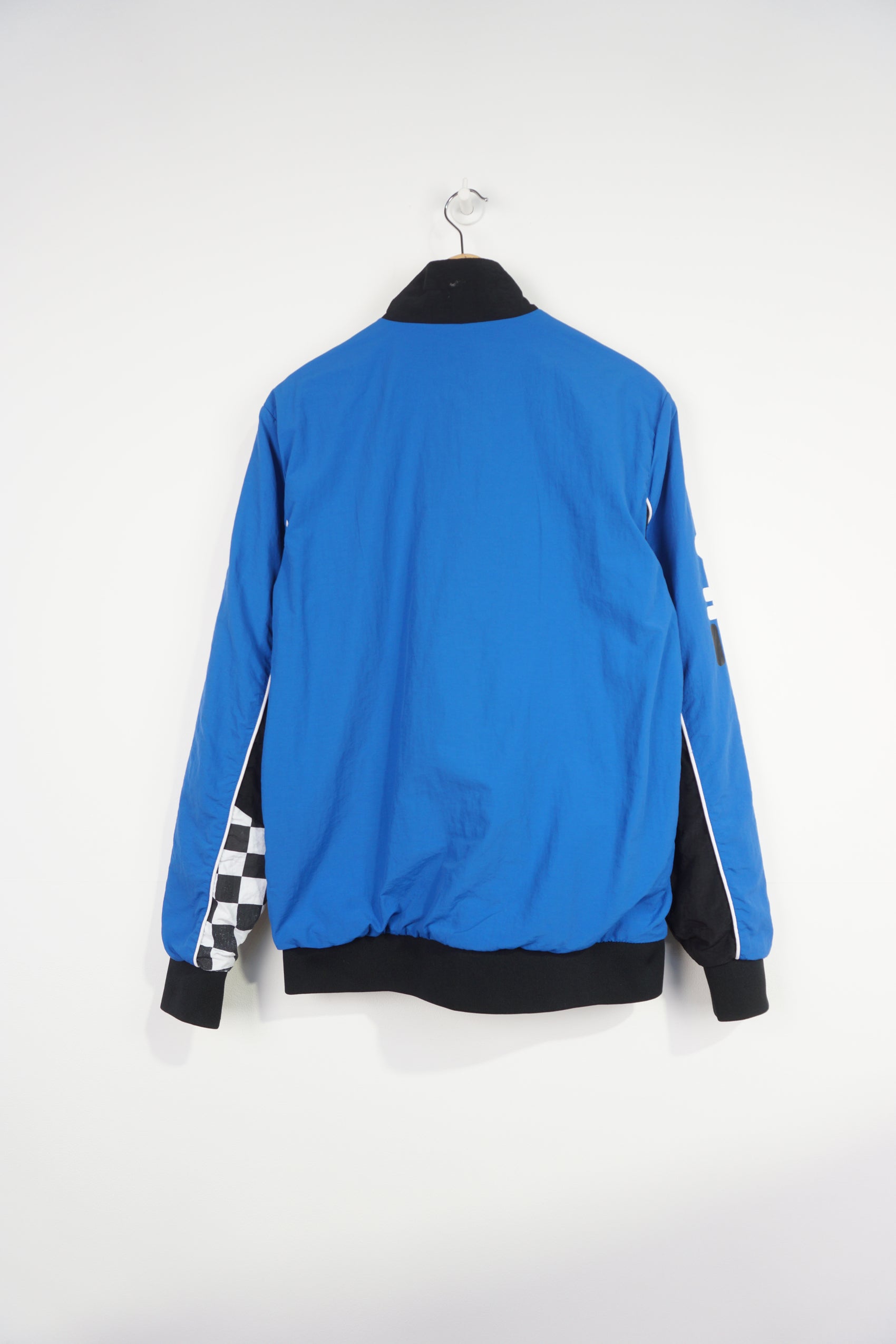 Vintage blue and black Fila Italia Motor Racing jacket features printed logos on the front and checker flag cuffs