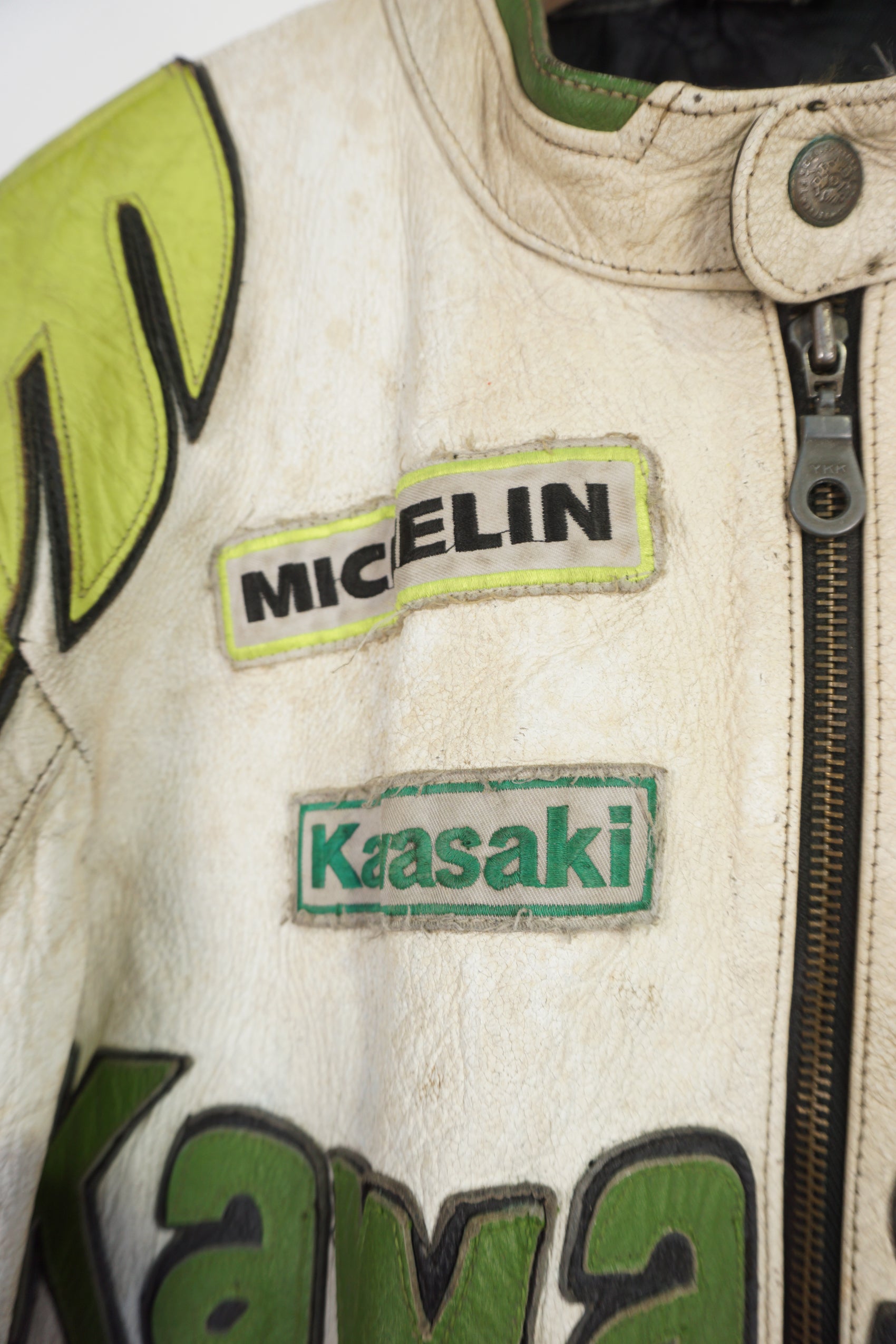 Vintage Kawasaki green & white leather motorcycle jacket features embroidered spell-out details, badges and sponsors