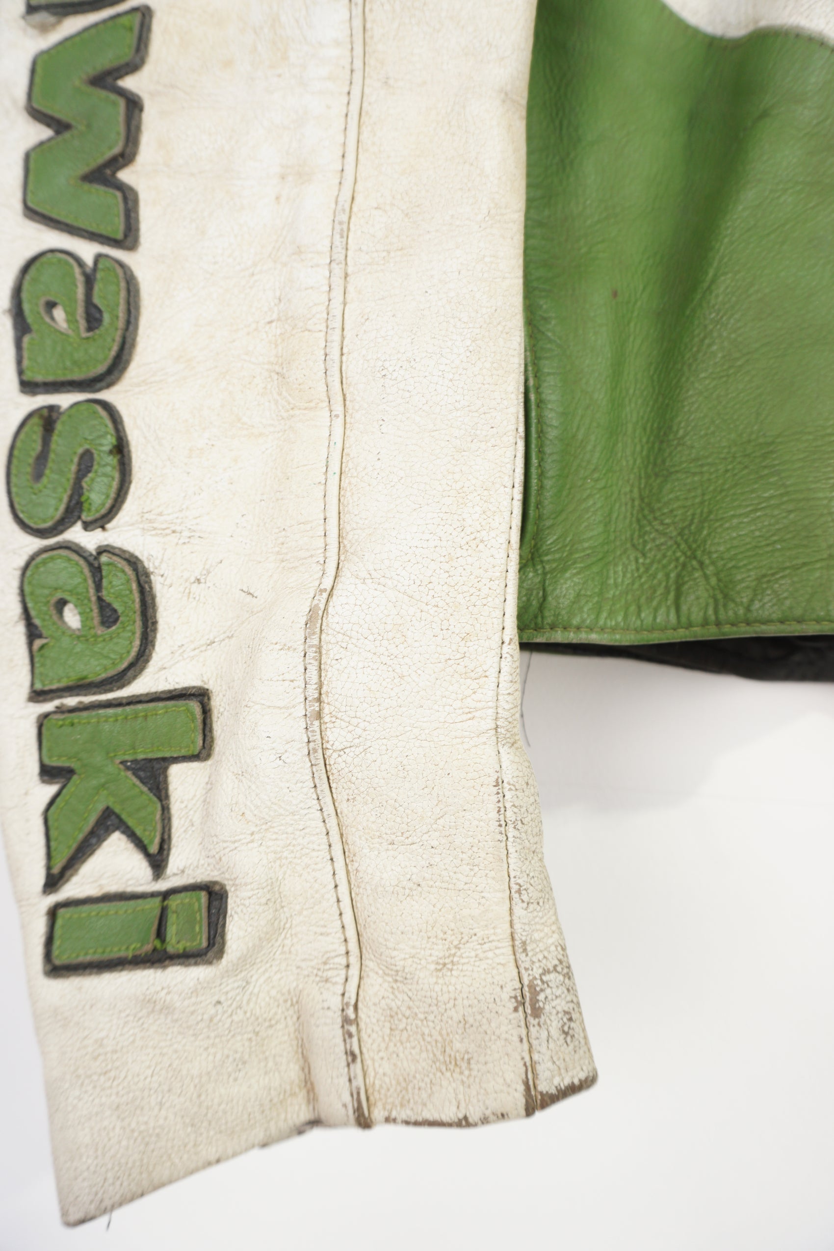 Vintage Kawasaki green & white leather motorcycle jacket features embroidered spell-out details, badges and sponsors