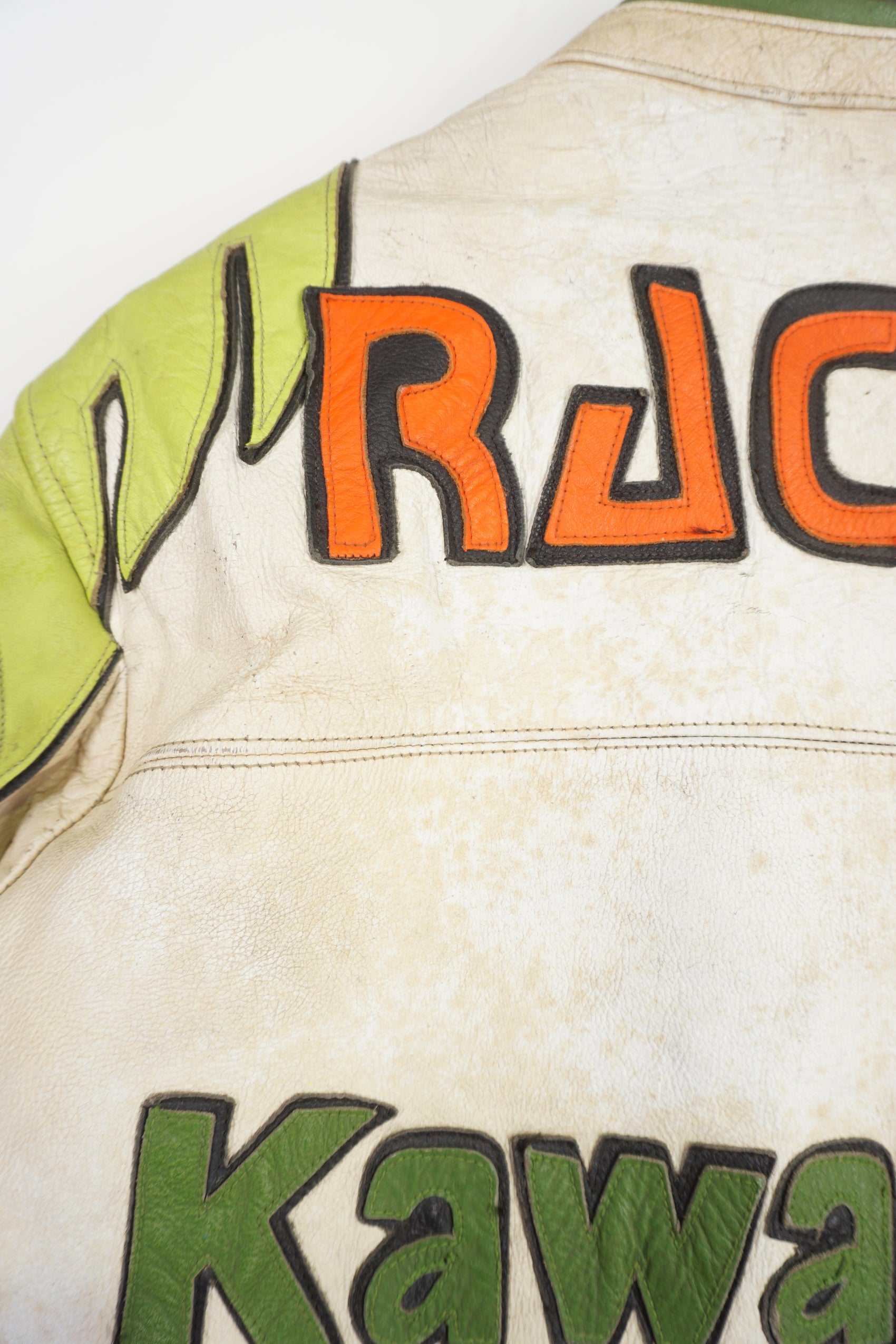 Vintage Kawasaki green & white leather motorcycle jacket features embroidered spell-out details, badges and sponsors