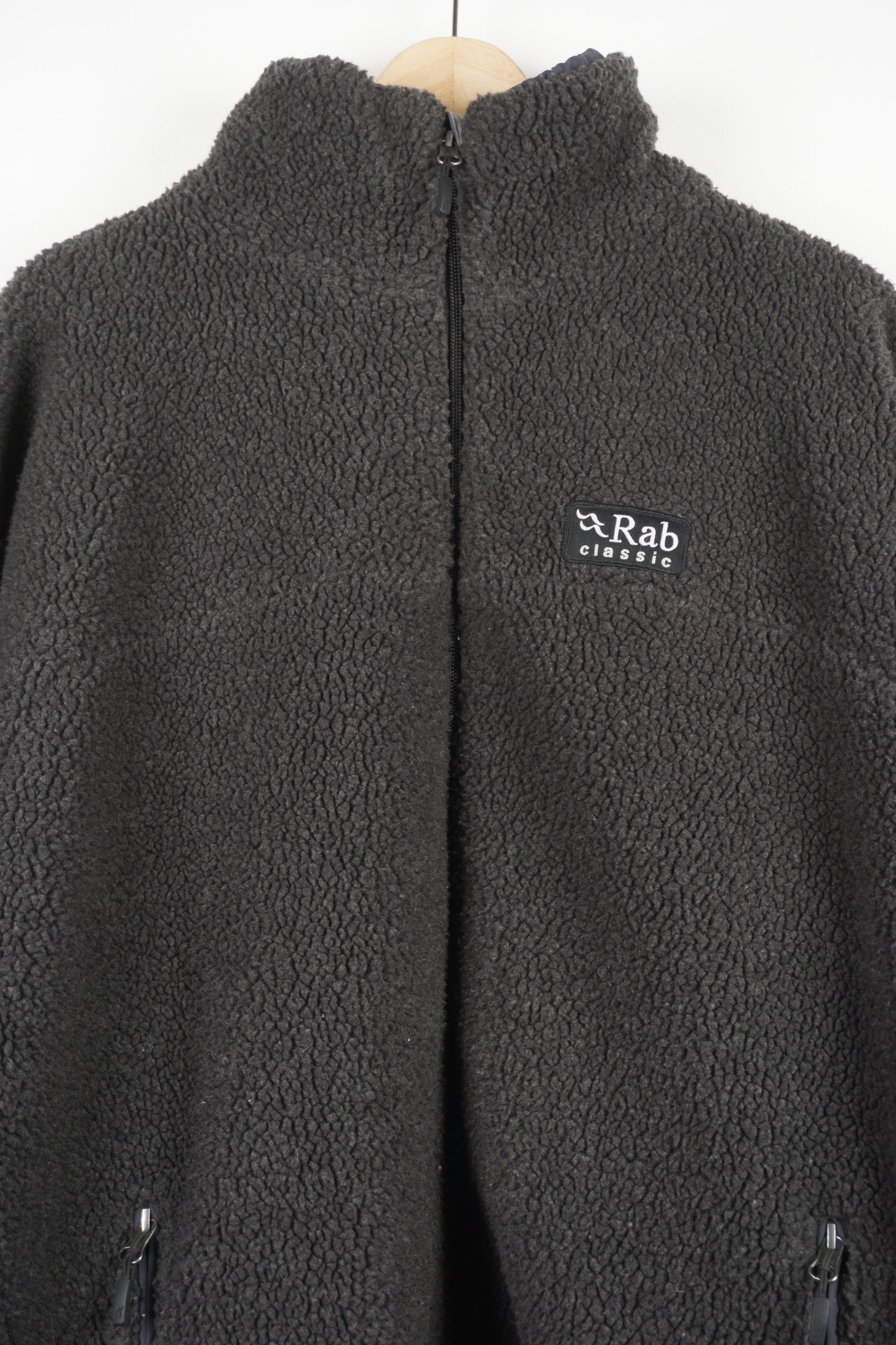 RAB dark grey teddy style zip through fleece features embroidered logo on the chest