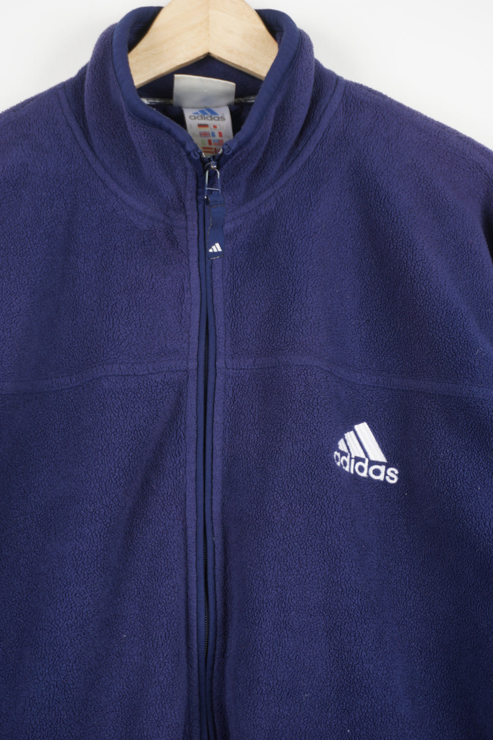 90s Adidas navy blue zip-through fleece features three stripe detail down the sides and embroidered logo on the chest