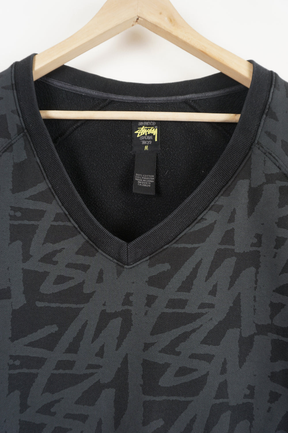 Stussy black v-neck sweatshirt with spell-out graphic all over