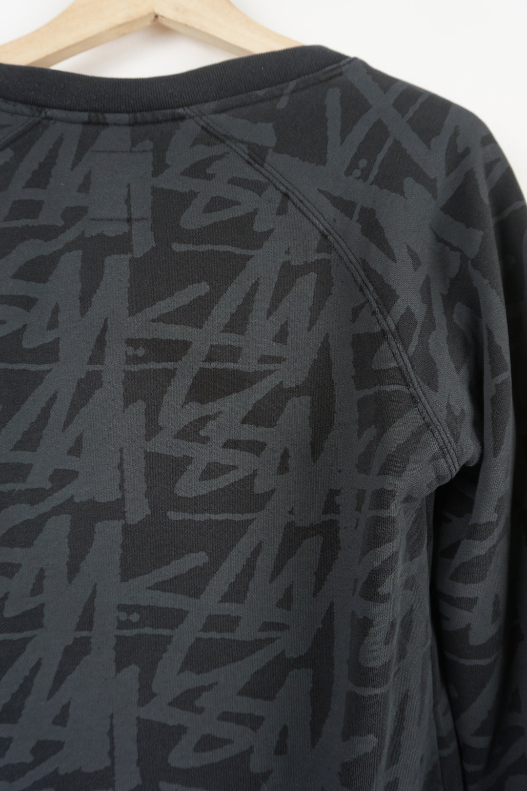 Stussy black v-neck sweatshirt with spell-out graphic all over