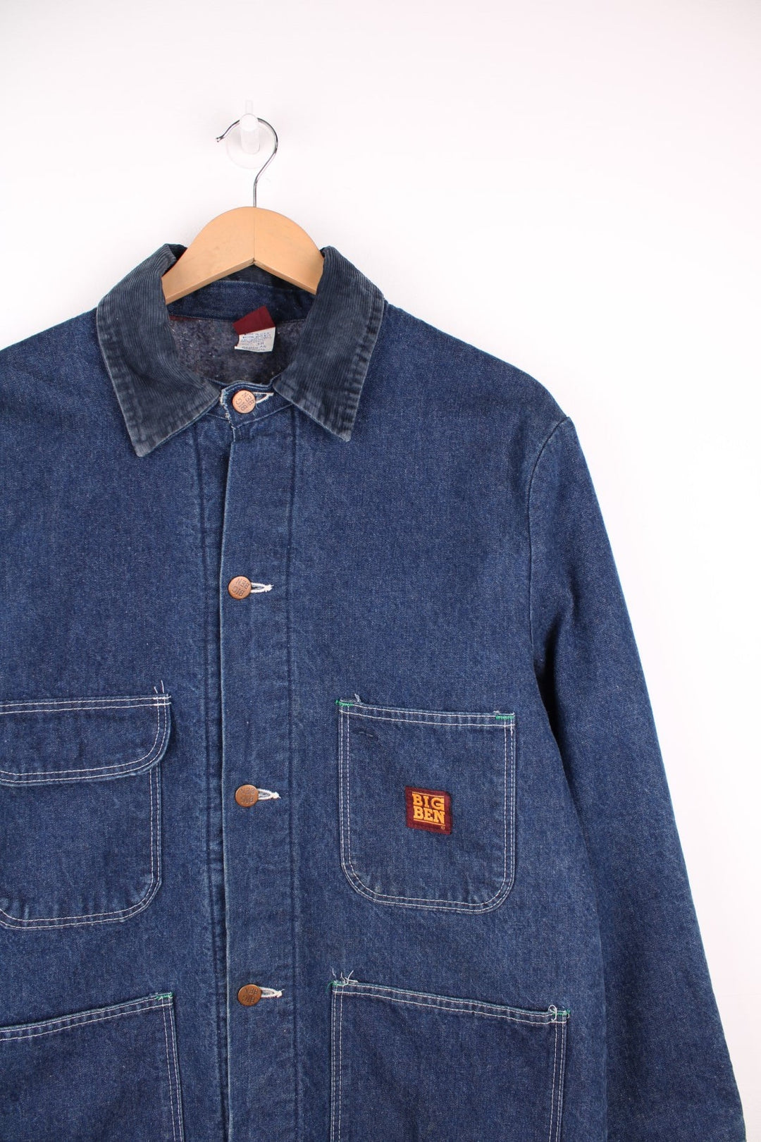 Big Ben by Wrangler Denim Chore Coat in a blue colourway with a corduroy collar, button up with multiple pockets, has a blanket lining, and the logo embroidered on the front. 